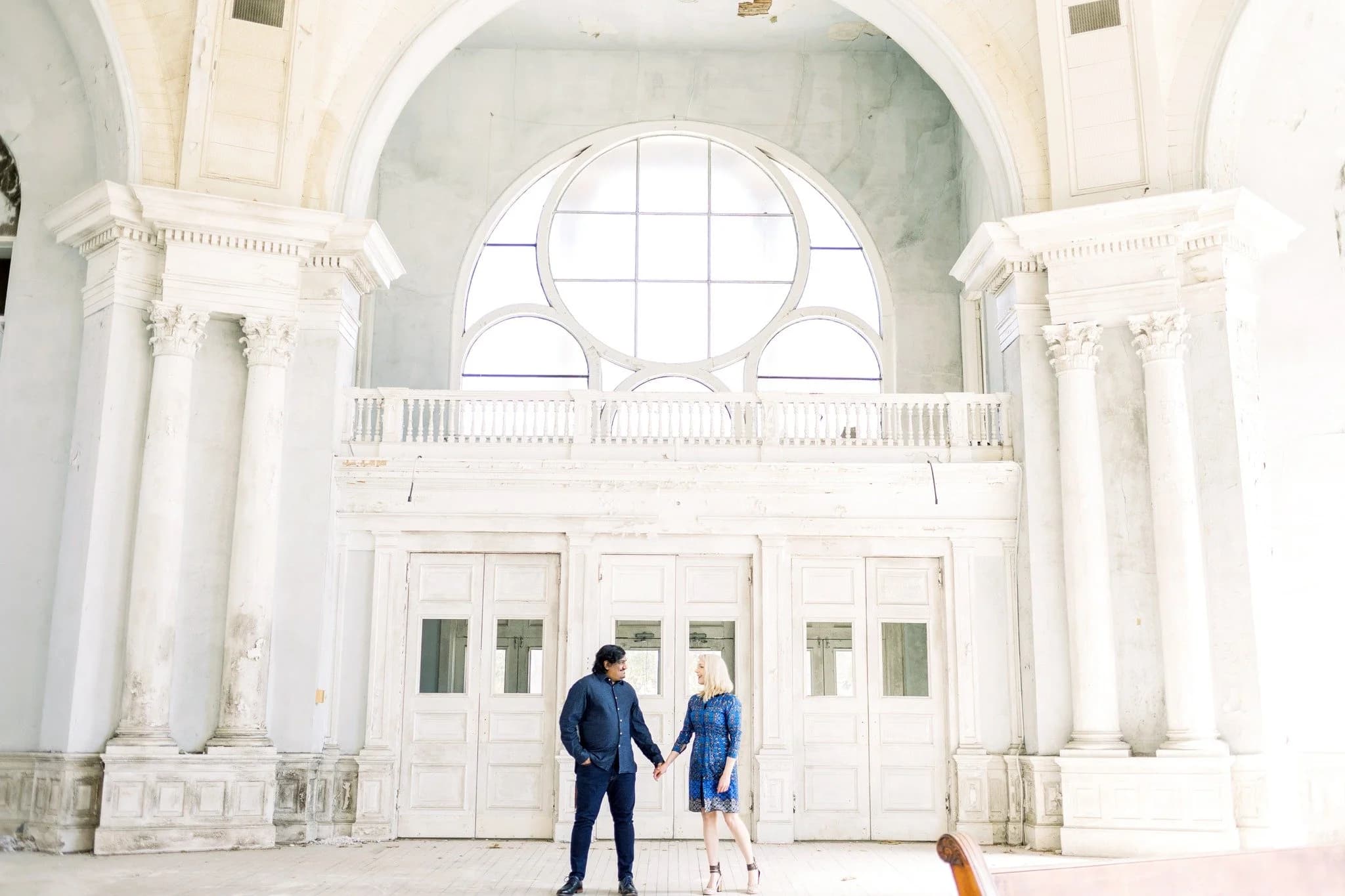 Two people walking beneath a grand archway